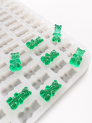 Angled close-up of the 1.5mL 296-cavity gummy bear mold with translucent emerald green gummies