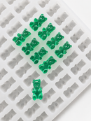 Close-up view of a 1.5mL gummy bear mold showing bear-shaped cavities and emerald green gummy samples